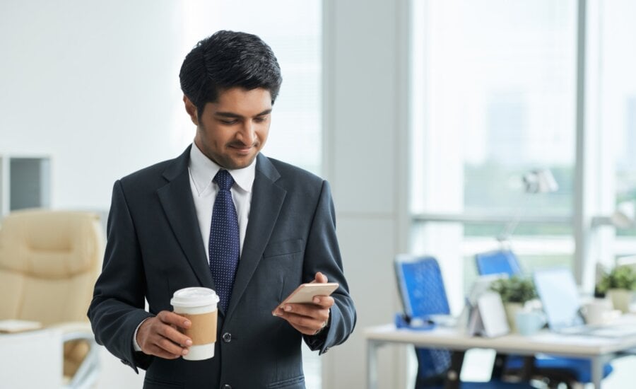 A man reviews his capital losses on his cellphone at the office