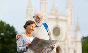 A retired couple look at a map while traveling across Europe