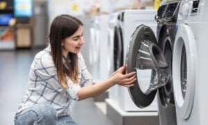 A Canadian woman looking at a washing machine to buy it.