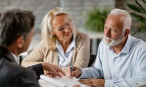 A retired couple speak with an accountant about the tax implications of their inherited property