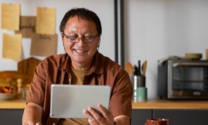 A man named Jing on his tablet at home