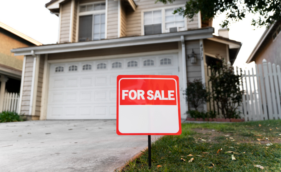 House with a for sale sign on the front lawn.