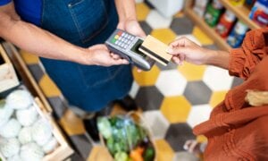 A customer uses her credit card to pay for groceries