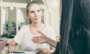 A woman receives financial advice from a friend