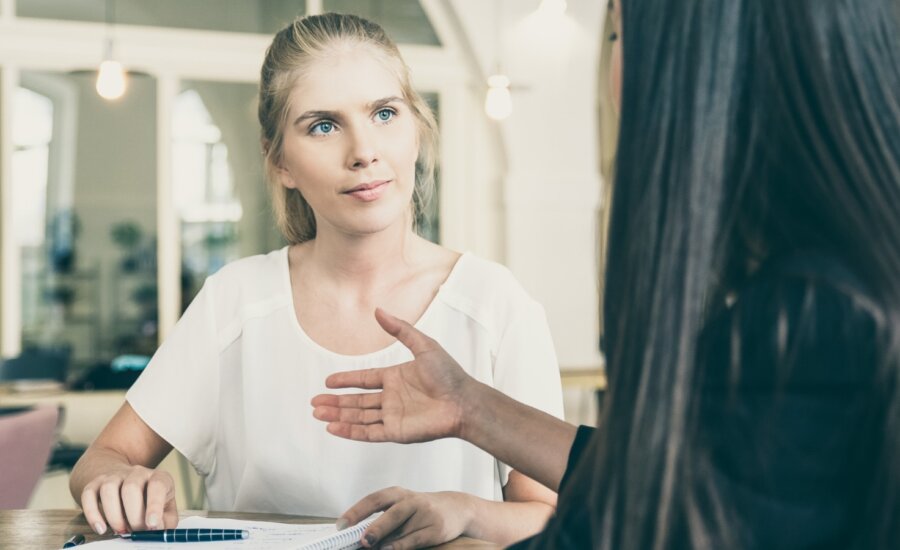 A woman receives financial advice from a friend