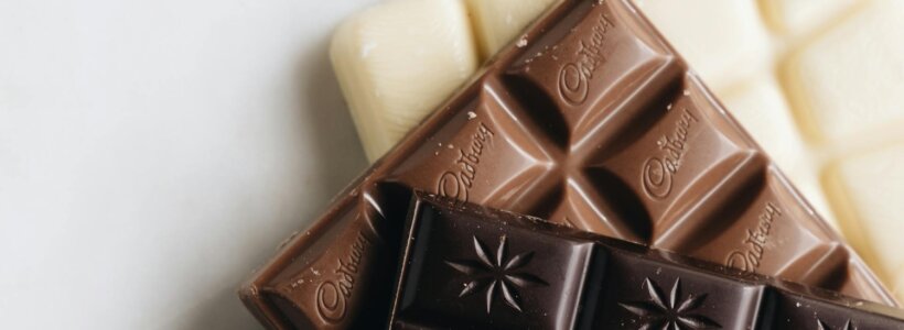 Dark, milk and white chocolate bars stacked on top of each other