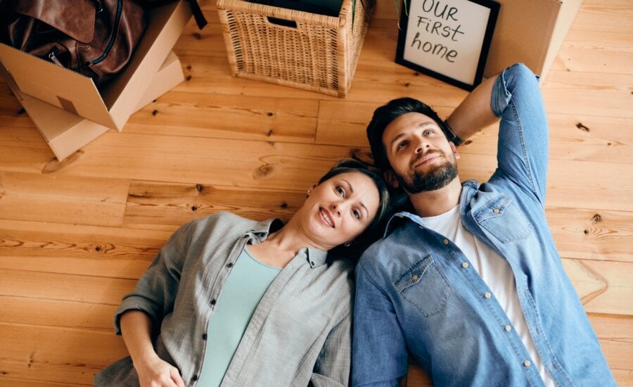 A couple lies on the floor of their new home