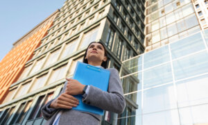 A woman looking for work in an urban centre, wondering, "Will Canada go into a recession in 2024?"