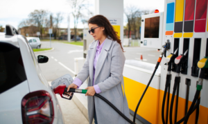 A woman fills up her car with gas