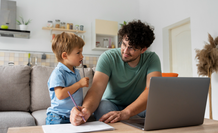 A father and young son draw together in a living room.