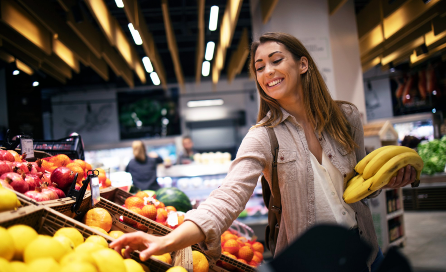 A smiling woman buying fruit at the supermarket