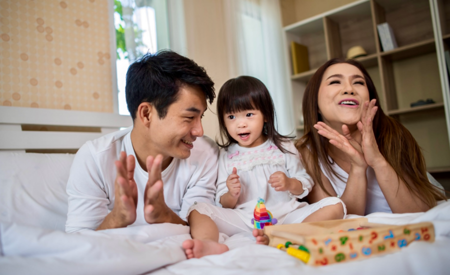 A young mom and dad sing with their toddler daughter
