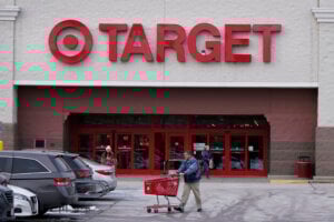 A shopper wheels a cart through the parking lot after making a purchase at the Target store, Monday, Feb. 27, 2023, in Salem, N.H. Target is recalling almost 5 million candles over laceration and burn hazards, according to a Thursday notice published by the U.S. Consumer Product Safety Commission.