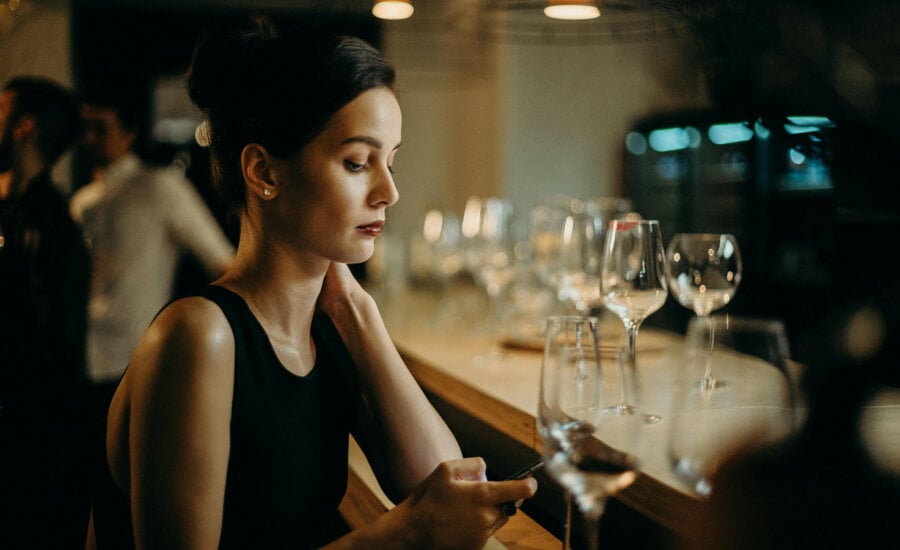 A Canadian single woman at work, looking at her investments on her phone.