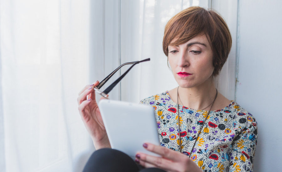 A woman reads messages on her tablet