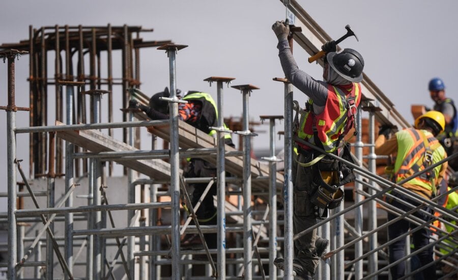 Construction workers work at the site of a condo tower under construction, in Delta, B.C., on Wednesday, July 2, 2025.