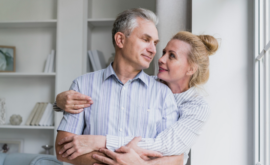 A man and woman hug in their living room