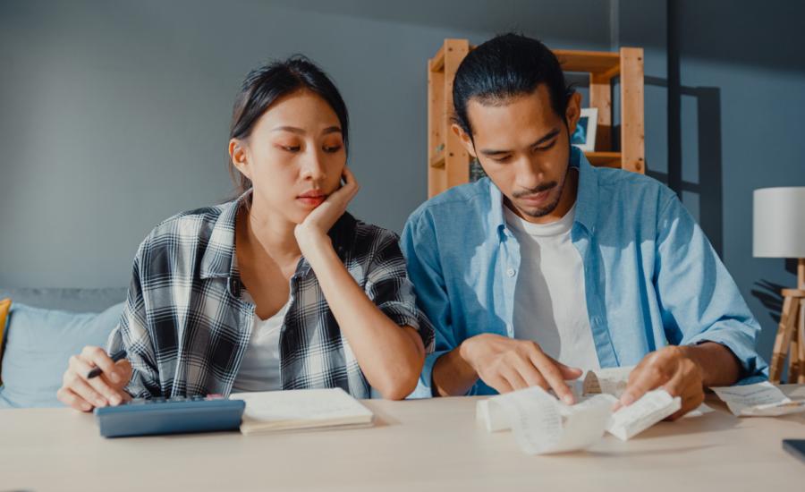A young man and woman add up several receipts