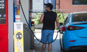 A man pumps gas into a sedan