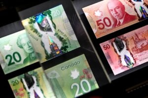 A magnifying glass enlarges the holographic image of Parliament Hill's Peace Tower on a 20 dollar bill issued by the Bank of Canada, shown in a display case at the Bank of Canada Museum in Ottawa, on Wednesday, Sept. 4, 2024. The Bank of Canada says Canadians were keeping more cash on hand in 2024