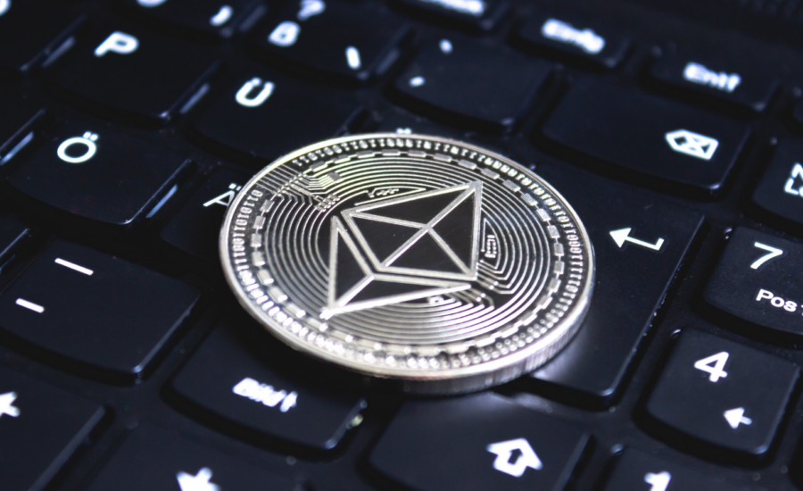 A silver ethereum coin sits on a computer keyboard