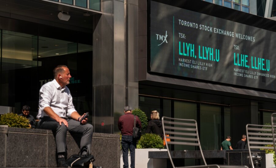 People sit outside the TMX Market Centre in Toronto, Wednesday, Sept. 11, 2024.