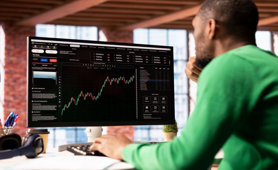 Man sitting at a computer buying stocks