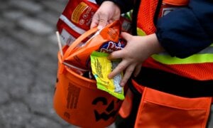 A child's bucket is full of candy as they go trick-or-treating at Rideau Hall on Halloween in Ottawa on Monday, Oct. 31, 2022.