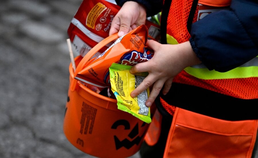 A child's bucket is full of candy as they go trick-or-treating at Rideau Hall on Halloween in Ottawa on Monday, Oct. 31, 2022.
