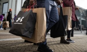 A person carries bags after shopping at the McArthurGlen Designer Outlet on Boxing Day in Richmond, B.C., Thursday, Dec. 26, 2024.