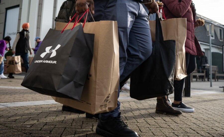 A person carries bags after shopping at the McArthurGlen Designer Outlet on Boxing Day in Richmond, B.C., Thursday, Dec. 26, 2024.