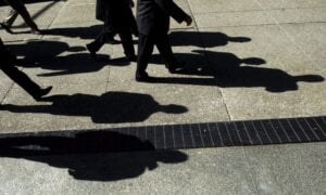 People cast shadows as they walk in Toronto's financial district