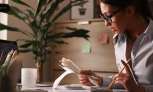 Female accountant calculating tax bills while working on finances in the office.