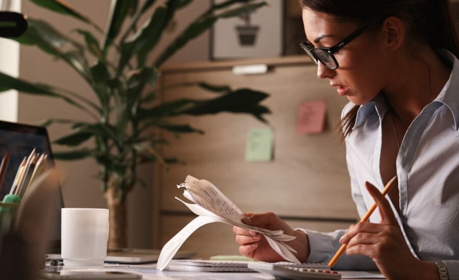 Female accountant calculating tax bills while working on finances in the office.