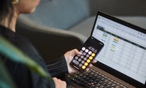 A person uses the calculator app on their phone and works on a spreadsheet in a photo illustration made in Toronto, on Monday, Sept. 22, 2025.