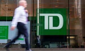 A person makes their way past a Toronto-Dominion Bank in the Financial District of Toronto, Monday, Aug. 14, 2023.