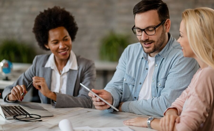 Couple using a tablet while in a meeting with a banking professional.