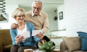 Happy senior couple feeling nostalgic while looking at their photo album at home.