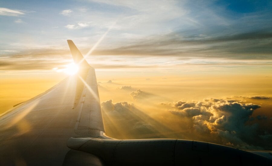 View of a plane wing while flying at sunset