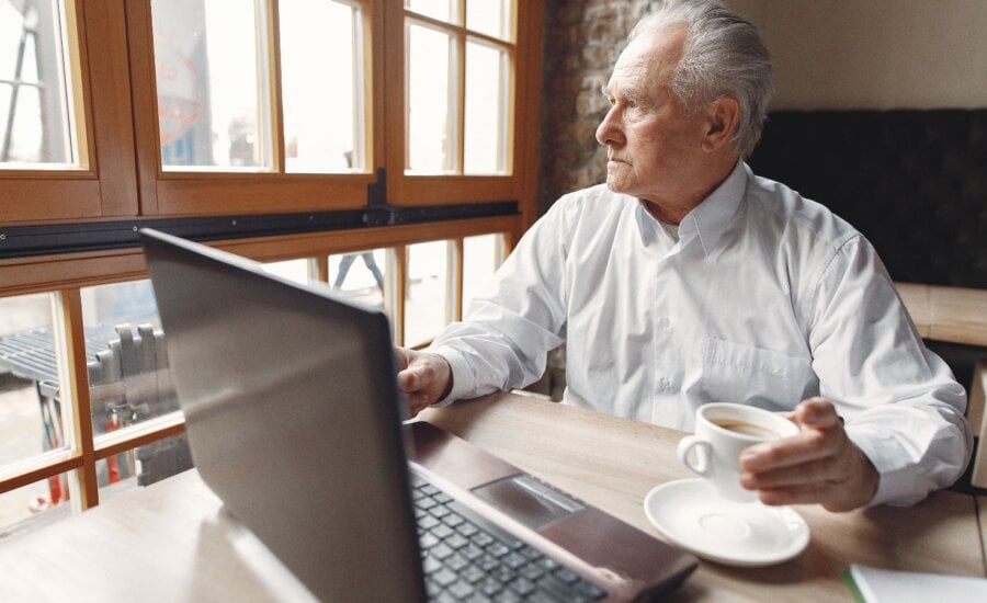Senior man sitting at a desk with a computer