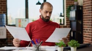 Man sitting at desk examining papers