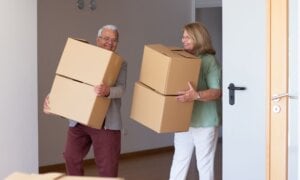 Senior couple moving boxes into a new home