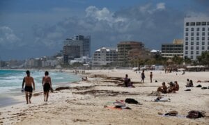 Tourists enjoy the beach before the arrival of Hurricane Grace, in Cancun, Quintana Roo State, Mexico, Wednesday, Aug. 18, 2021. Residents and tourists along the Caribbean coast began making preparations for Grace, a storm that drenched Haiti and Jamaica and is now forecast to hit Mexico´s Yucatan peninsula like a hurricane early Thursday morning.