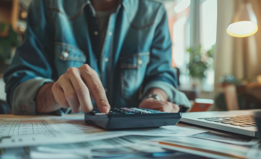 Person sitting at a desk using a calculator