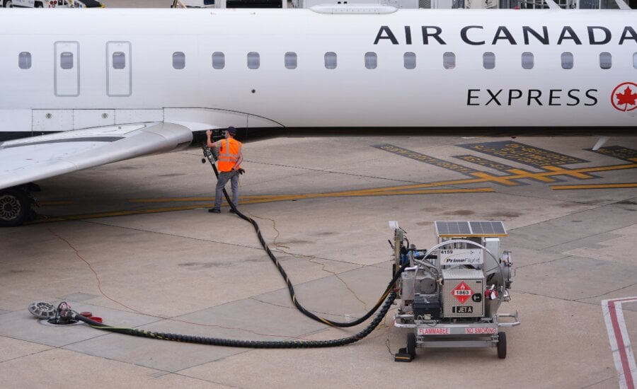 FILE - A worker fuels an Air Canada jet at DFW International Airport in Grapevine, Texas, Tuesday, April 14, 2026.