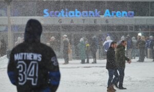 Toronto Maple Leafs fans line up in a snowstorm as they wait to enter Scotiabank arena ahead of NHL hockey action against the Colorado Avalanche in Toronto, on Sunday, Jan. 25, 2026.