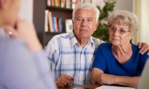 Senior couple sitting in a office meeting.