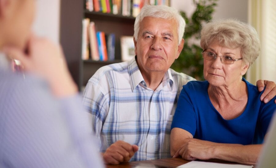 Senior couple sitting in a office meeting.