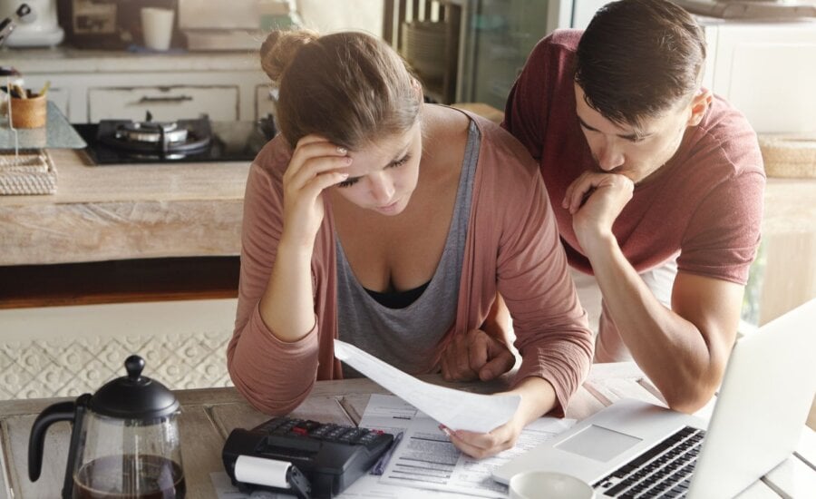 Couple looking at paperwork with worried expressions