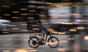 A food delivery worker rides a bike in downtown Vancouver, on Thursday, December 23, 2021.